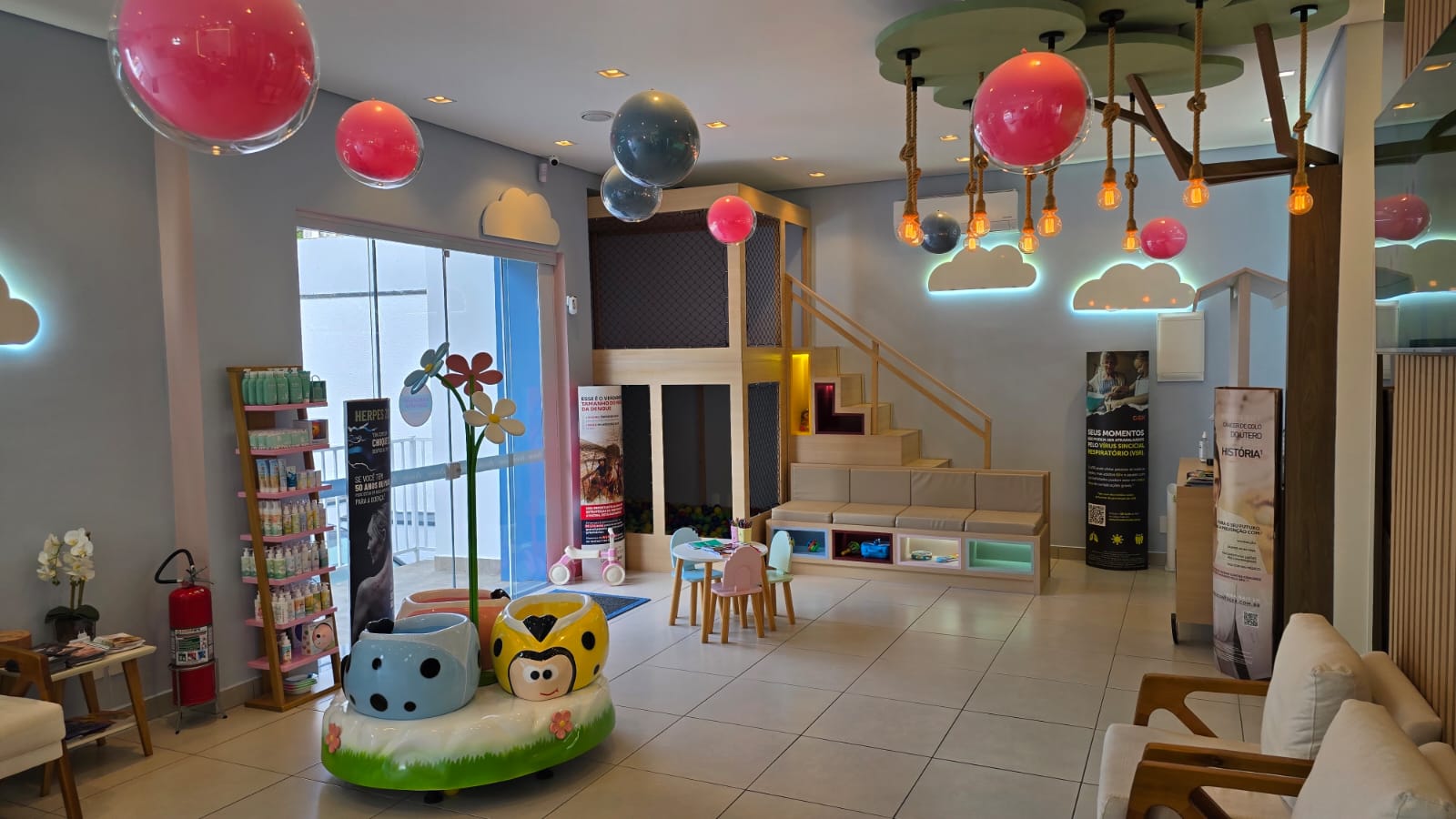 Recepção lúdica da Acolle em Jundiaí com balões coloridos, nuvens iluminadas, piscina de bolinhas e brinquedos